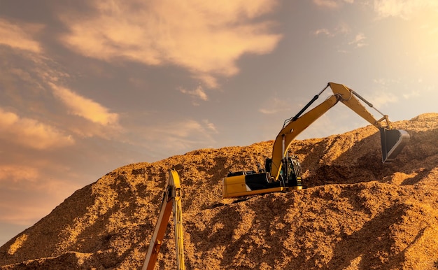 Backhoe working on huge sawdust pile in paper production\
factory bucket of digger digging wood chip