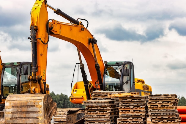 Backlit excavator on an industrial site against the background\
of the evening sky construction machinery for earthworks