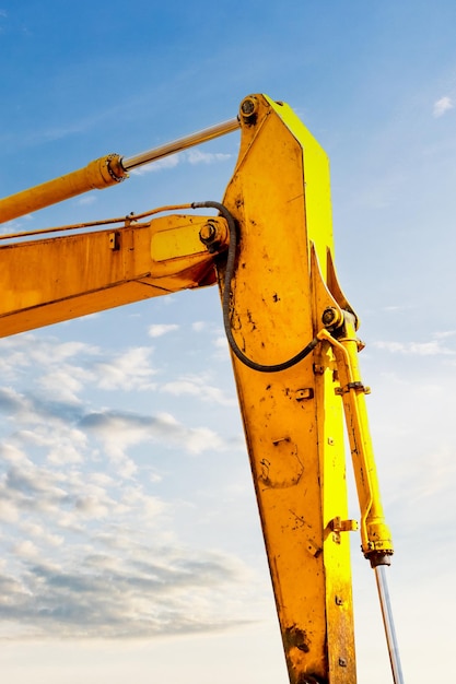 Backlit excavator on an industrial site against the background\
of the evening sky construction machinery for earthworks