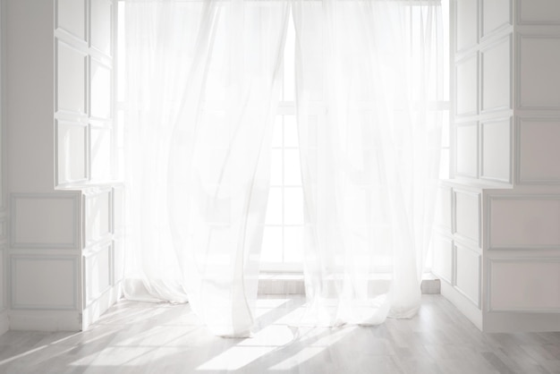 Backlit window with white curtains in empty room