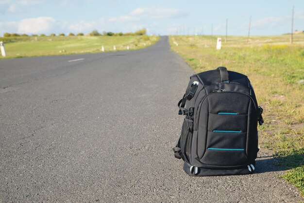 Backpack on asphalt road Adventure and travel