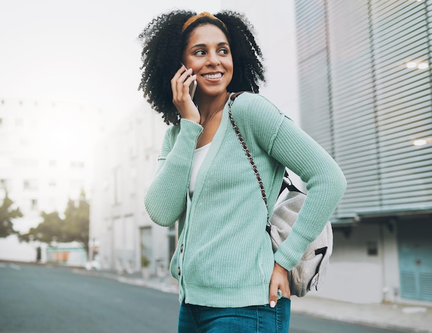 Backpack phone call and student in city street walking to university listening to results or feedback on internship opportunity Happy black woman with smartphone call talking outdoor in urban road