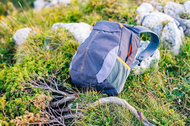 Backpack stands on top on the background of mountains stretching to the horizon on a sunny day