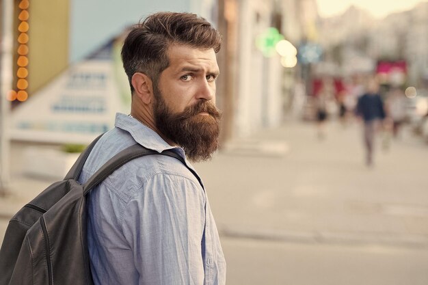 Backpack for urban traveling hipster backpack urban street\
background tourism and backpacking vacation concept modern rest\
bearded man travel guy exploring city discover local showplace