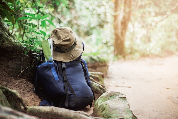 Backpack with map and hat on the ground