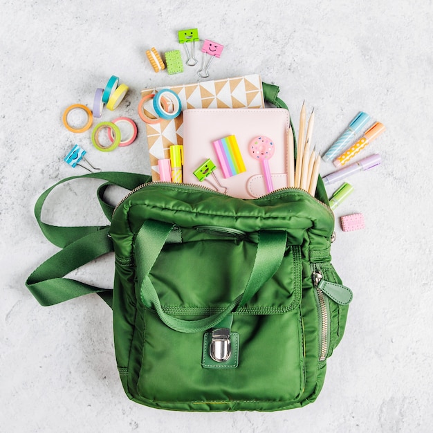 Backpack with school supplies and books for study. Back to school concept. Flat lay, top view