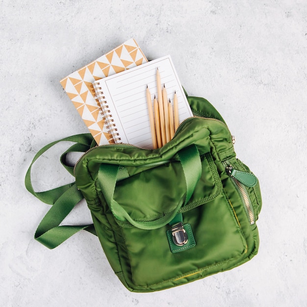 Backpack with school supplies and books for study. Back to school concept. Flat lay, top view
