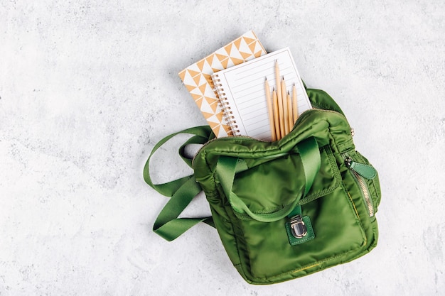 Zaino con materiale scolastico e libri per lo studio. torna al concetto di scuola. disposizione piatta, vista dall'alto