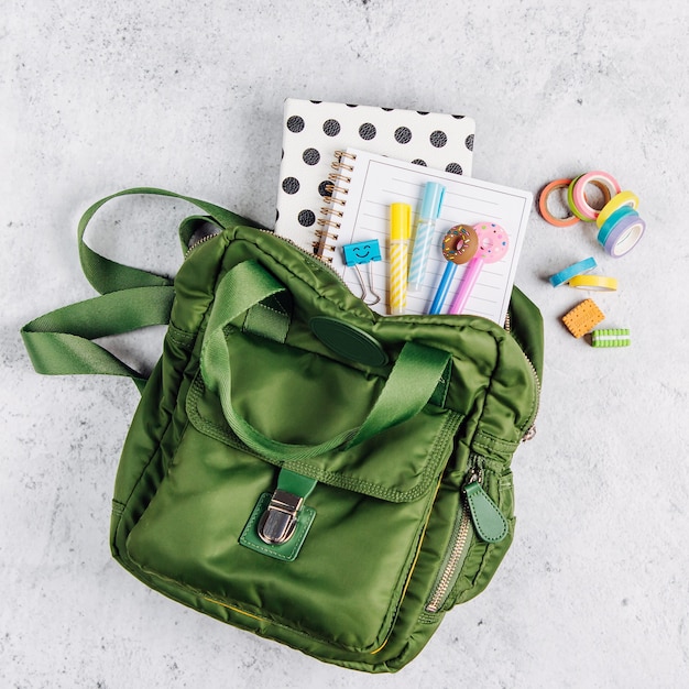 Backpack with school supplies and books for study. Back to school concept. Flat lay, top view