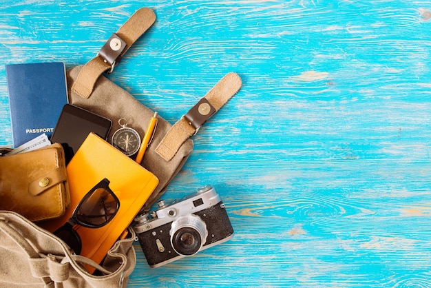 Foto zaino con occhiali da sole denaro passaporto concetto di viaggio roba su sfondo di legno blu copia spazio