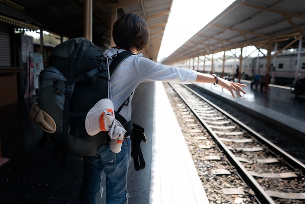 Backpack with traveler at the train station.  Travel concept.