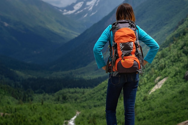 Backpacker bovenop een berg met uitzicht op de vallei