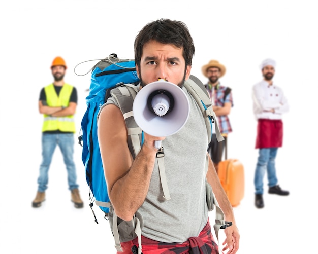 Backpacker shouting by megaphone over white background