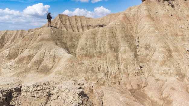 A backpacker standing on top of the rocky dunes enjoying the desert landscape