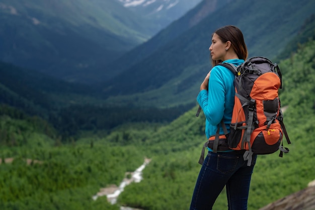 Backpacker on top of a mountain enjoying valley view