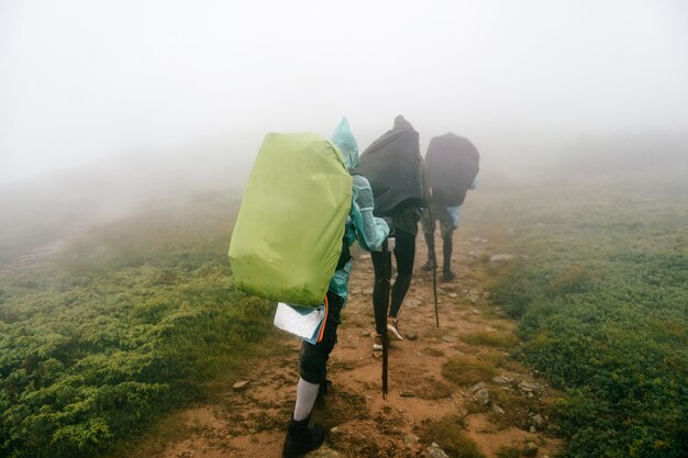 Backpackers hiking up the foggy mountains