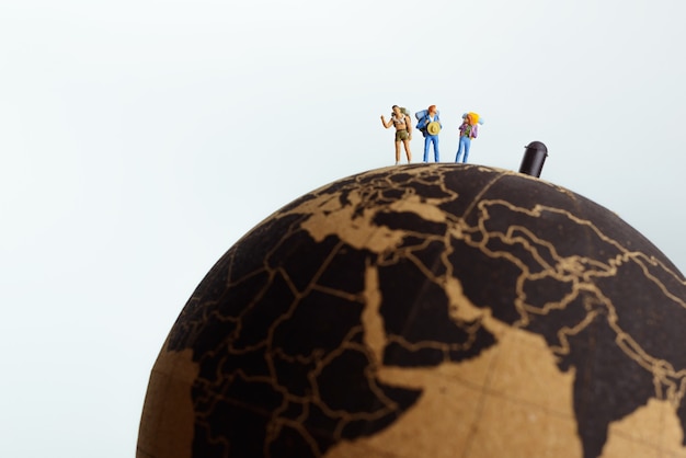 backpackers on top of a globe