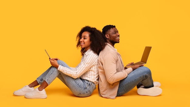 Backtoback black couple with gadgets on yellow background