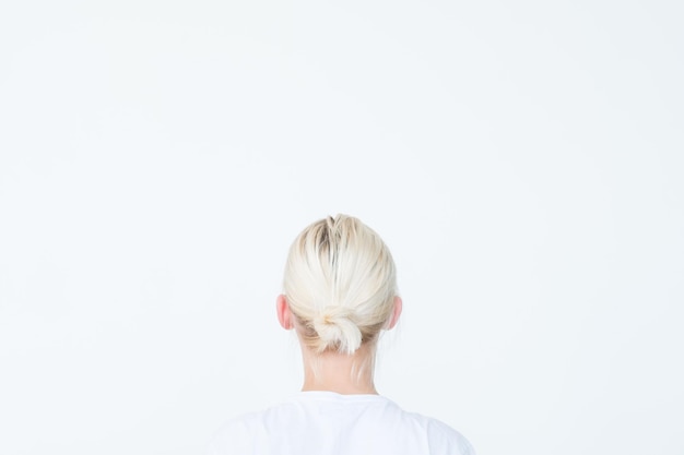 Photo backview of a woman looking at invisible virtual object on white background