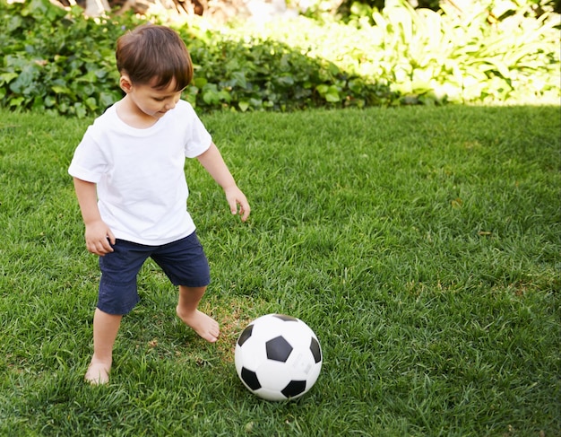 Calcio in cortile un ragazzino dolce con un pallone da calcio nel cortile di casa