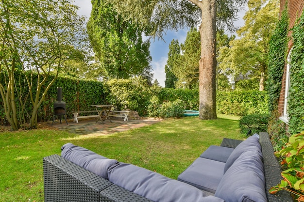 A backyard with lawn furniture and a tree