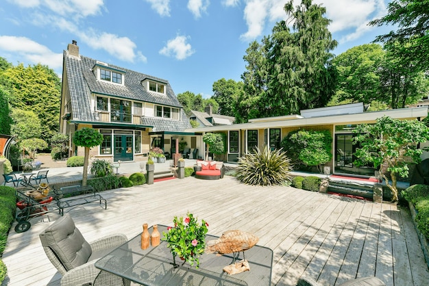 A backyard with a wooden deck and a house