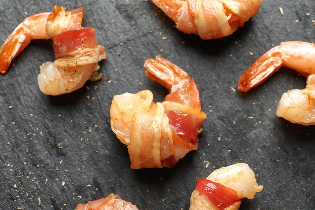 Bacon gewikkeld garnalen op leisteen plaat close-up