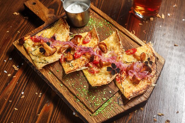 Bacon quesadilla on a wooden kitchen board with white sauce dark and moody top new