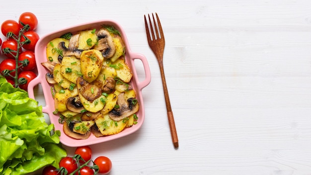 Bacon tartiflette on a baking dish with herbs and vegetables at
home on a wooden white background view from above the national dish
of potatoes copy space