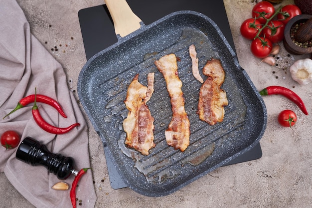 Bacon wordt gekookt in grill koekenpan Koekenpan bij binnenlandse keuken