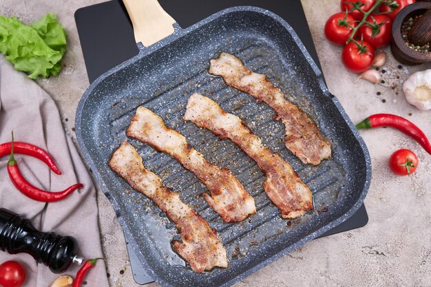 Bacon wordt gekookt in grill koekenpan Koekenpan bij binnenlandse keuken