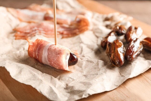 Bacon wrapped date on wooden board