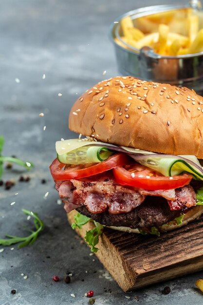 Baconburger met rundvleespasteitje. Amerikaans fastfood. patty burger met frietjes en dips maaltijd. verticaal beeld. plaats voor tekst.