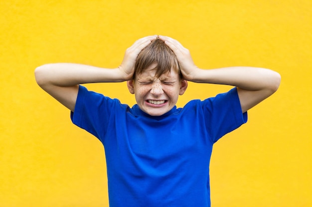 Foto cattive emozioni e sentimenti concetto mal di testa ragazzo che tocca la testa e ha un'emicrania