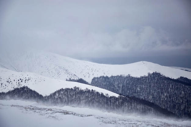 Bad weather in mountains Storm wind and dark clouds above snow covered mountain range Winter touristic trails in Carpathian mountains Borzhava Ukraine