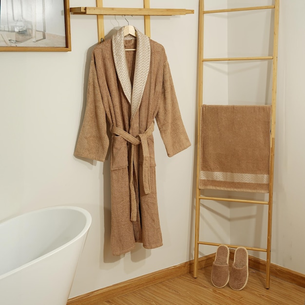 Foto badjas set hanger met schone badjas en handdoek op lichte muur badjas mockup