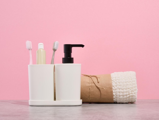 Badkamer set met schone douchedoek tandenborstels en tandpasta Vloeibare gel dispenser