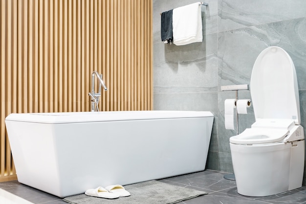 Badkamerinterieur met minimalistische douche, wit toilet, wastafel en ligbad