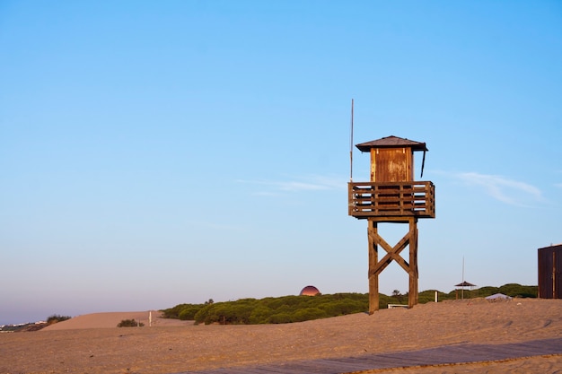 Foto badmeester toren op zand en blauwe hemel