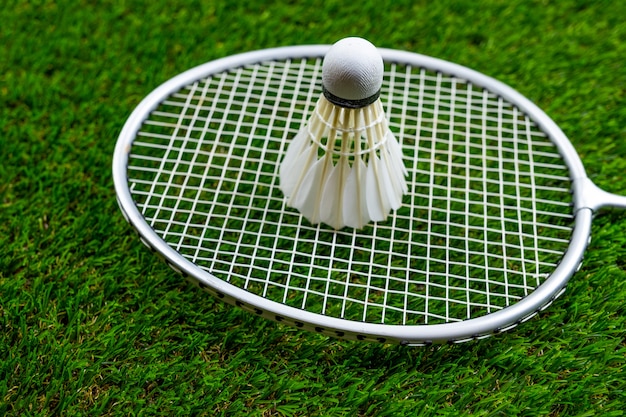 Badminton ball and racquet on grass