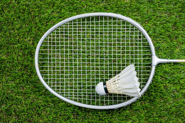 Badminton ball and racquet on grass