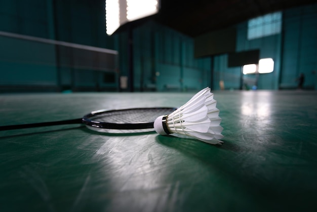 Badminton ball or shuttle cock with badminton racquet in court with professional badminton player play in court at gym for healthy and sport championship competition