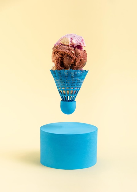 Photo badminton shuttlecock filled with scoops of ice cream above a blue roller