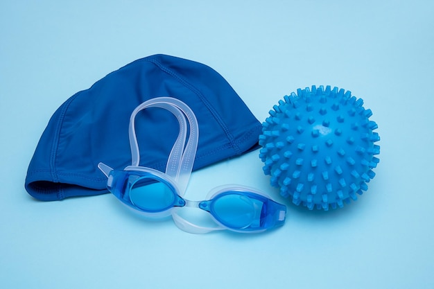 Badmutsbril en bal om in het water te spelen op een blauwe achtergrond