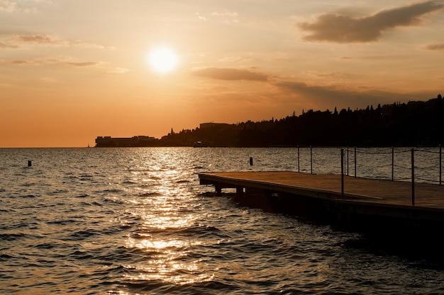 badplaats aan de Sloveense kust. oranje avondrood in de zomer. Schilderachtig uitzicht op houten pier. Zee