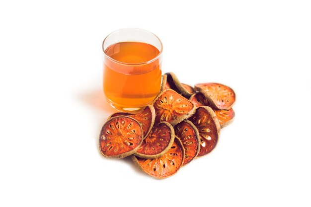 Bael fruit tea and slices of dried bael fruit tea matum isolated on white