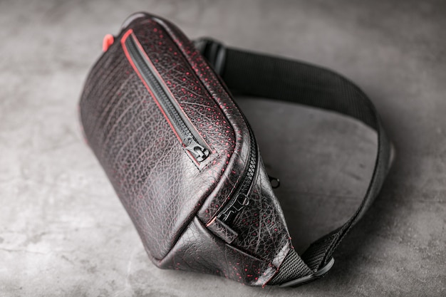 Bag on the belt of textured leather in Bordeaux colour  on gray