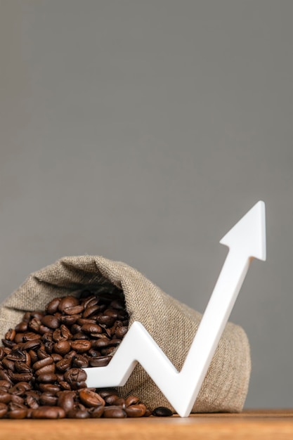 A bag of coffee beans and a chart arrow pointing up The cost of coffee in the markets of the world The concept of the growth of the cost of coffee beans