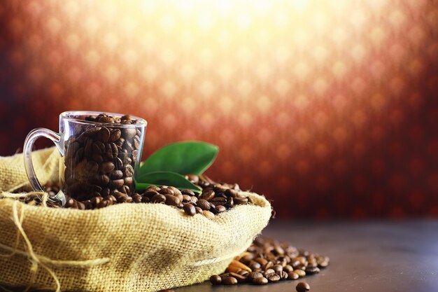 コーヒーの袋。テーブルの上で焙煎したコーヒー豆。調理用の緑の葉とコーヒー豆。