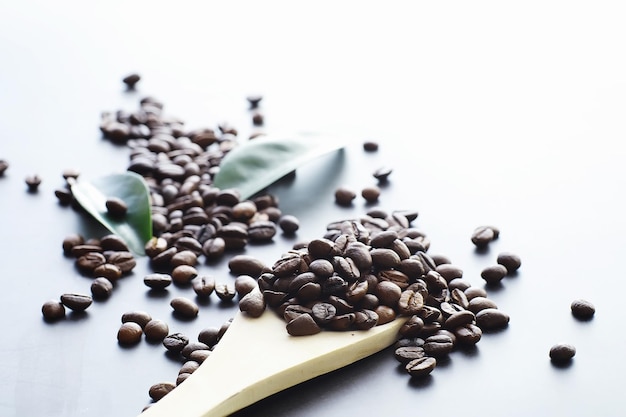 Bag of coffee. Coffee beans roasted on the table. Coffee beans with green leaves for cooking.